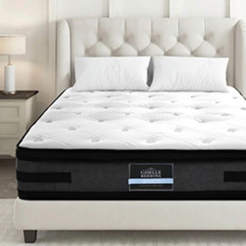Giselle Bedding mattress on a tufted bed frame in a bright bedroom.