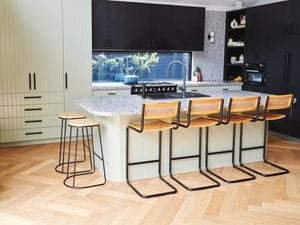 Kitchen with black taps and black chairs accompanied by stonetop