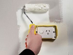 Using paint roller to paint walls
