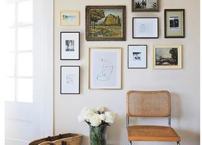 Framed pictures of different sizes on an off-white wall
