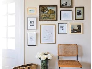 Framed pictures of different sizes on an off-white wall