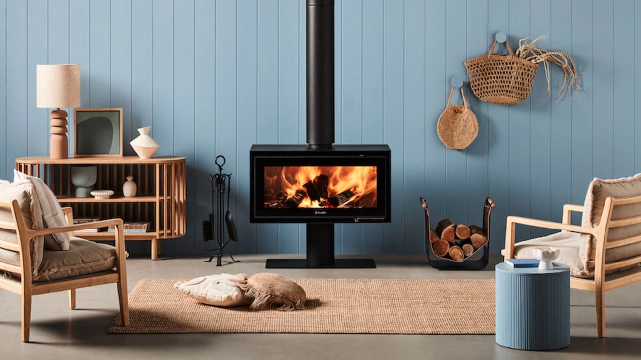 A black Fraam Sheer fireplace in a cream living room and black chairs and accessories