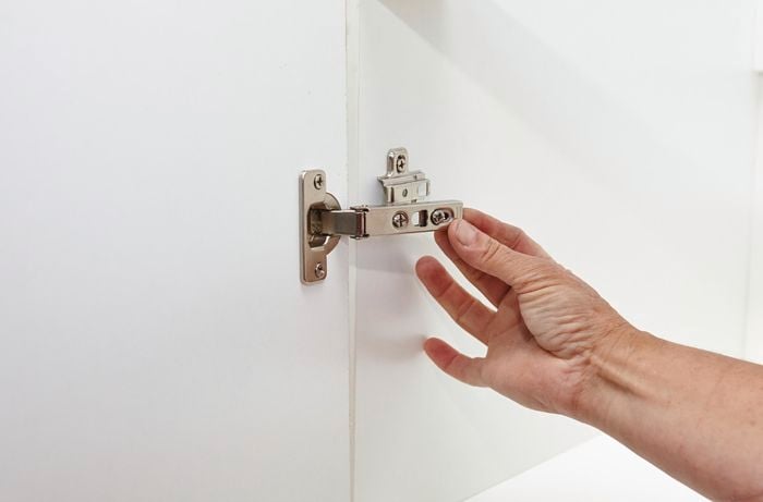 Person attaching doors to cupboard