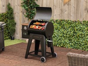 Pit Boss BBQ in yard with food cooking