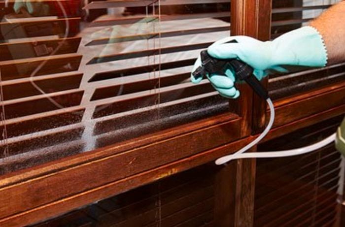 A Bunnings team member spraying windows with bug repellent