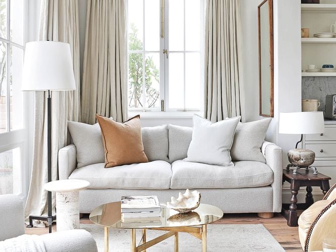 Living room with grey interior theme, a patterned grey rug with couch on top and two lamps beside the couch.