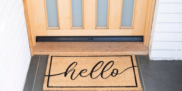 Front door with a doormat featuring the word "Hello".