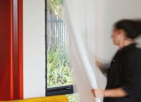 Person touching a curtain attached to a curtain rod