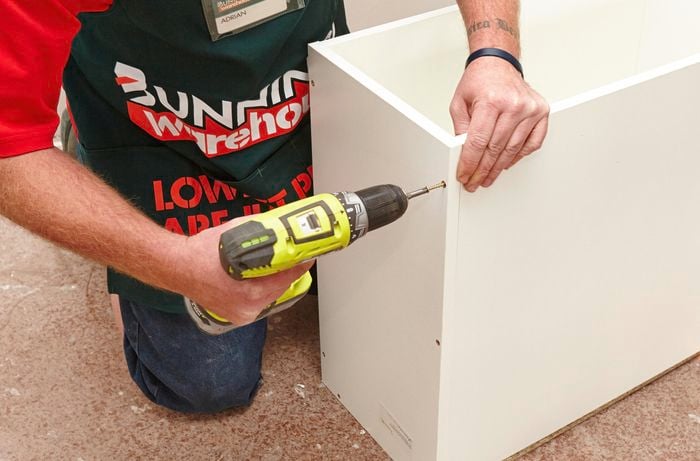 Person screwing cabinet panels together