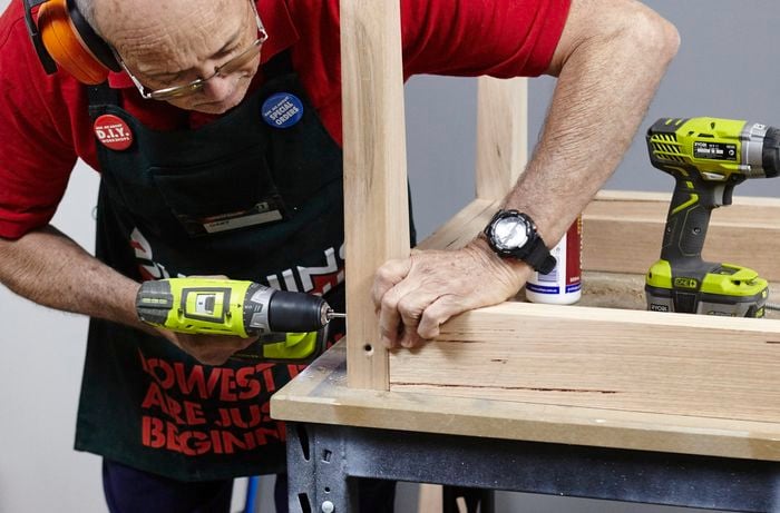 The framework of an outdoor table being assembled by a Bunnings team member