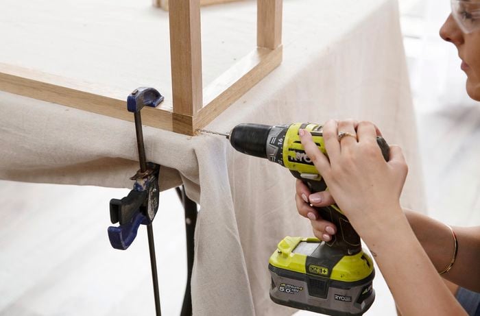 A hole being drilled into a wooden plant stand frame