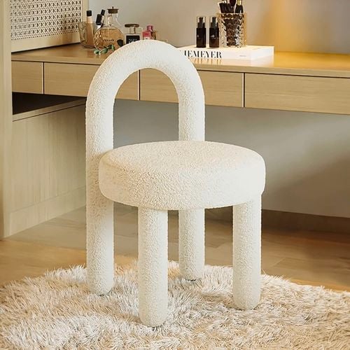 This boucle vanity chair brings cozy charm and playful curves to any modern space.