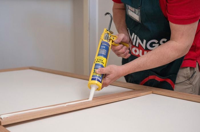 A person applying glue on the trim.