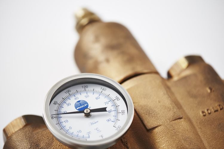 Brass plumbing fitting with pressure gauge