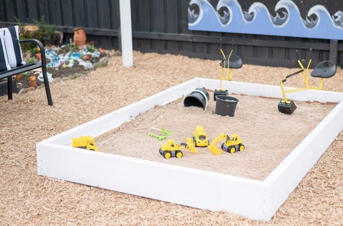 A white timber sandbox is made