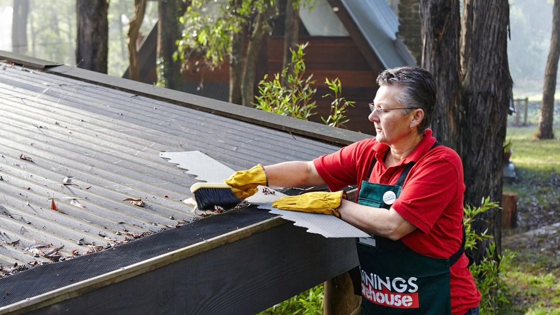 Person cleaning out roof gutters.
