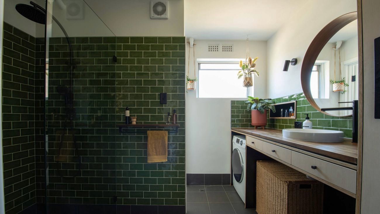 A wide shot of a green tiled bathroom/laundry