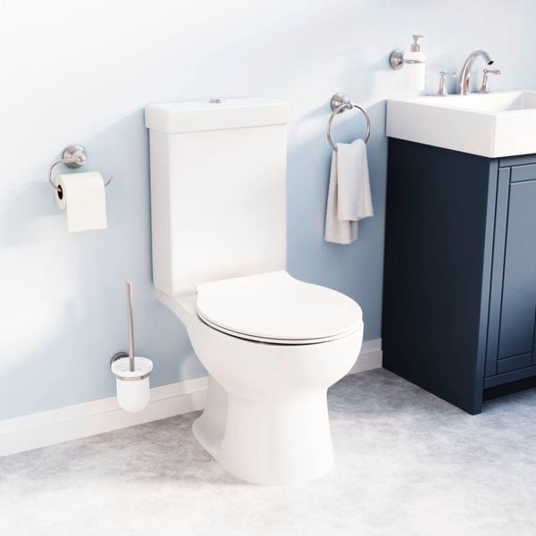 Bathroom with a dark vanity with a white sink on top of it and a white toilet in it.