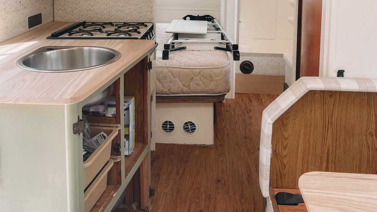The interior of a customer camper kitchen, with green cabinetry.
