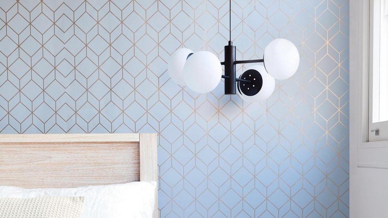 A black multi-globe pendant above a brass bedside table