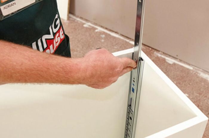 Drawer runners being added to the inside of a cabinet