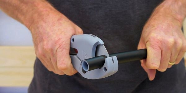 A person cutting a pipe.