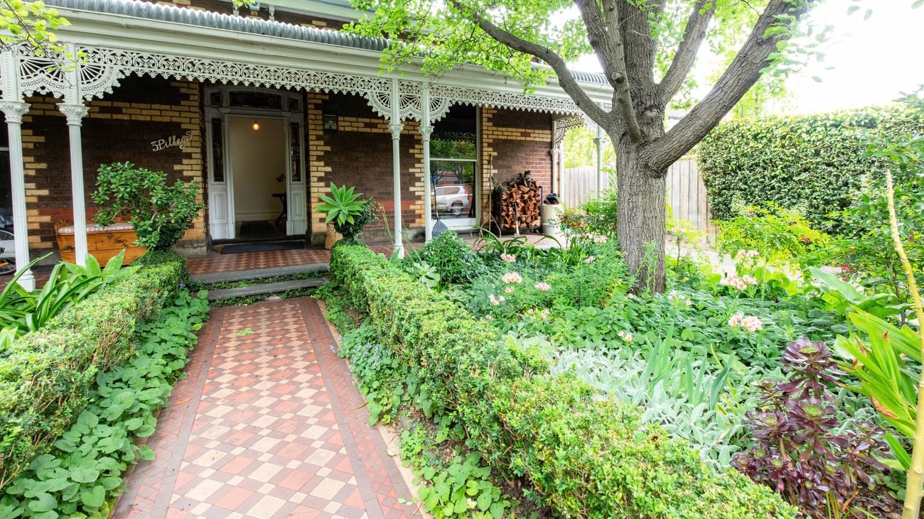Outside a burgundy brick home with door open