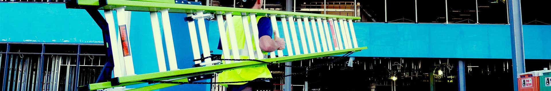 Person carrying Little Giant ladder into construction site