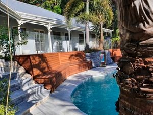 Brown timber built-in bench seating around a pool area is a perfect outdoor decking solution.