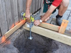 A Bunnings team member putting some timber supports over the holes.