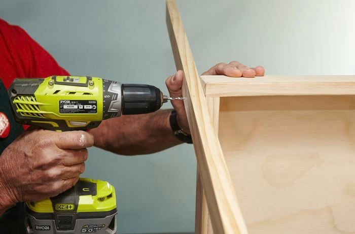 A person drilling through two pieces of timber