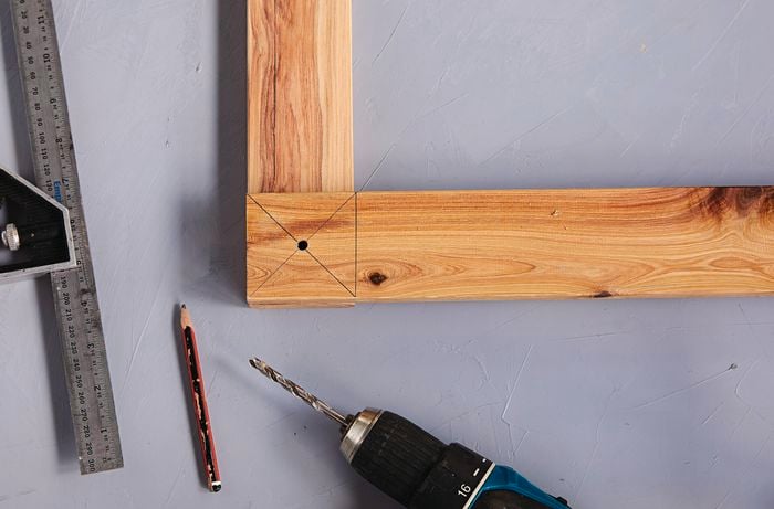 Corner joint of timber with set square, pencil and drill