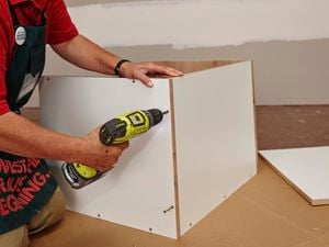 A microwave cabinet being assembled