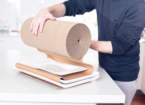 A person wrapping plates in paper wrapping, getting it ready to move house.