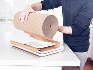 A person wrapping plates in paper wrapping, getting it ready to move house.