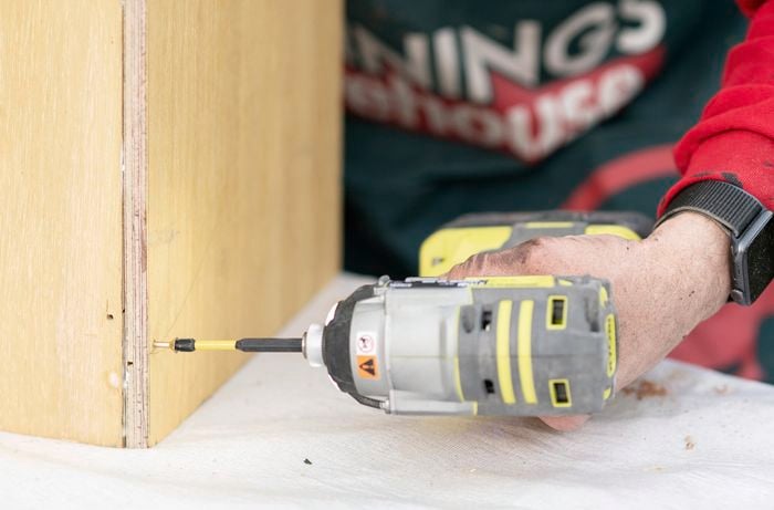 Screws being drilled into a wood join using a power drill