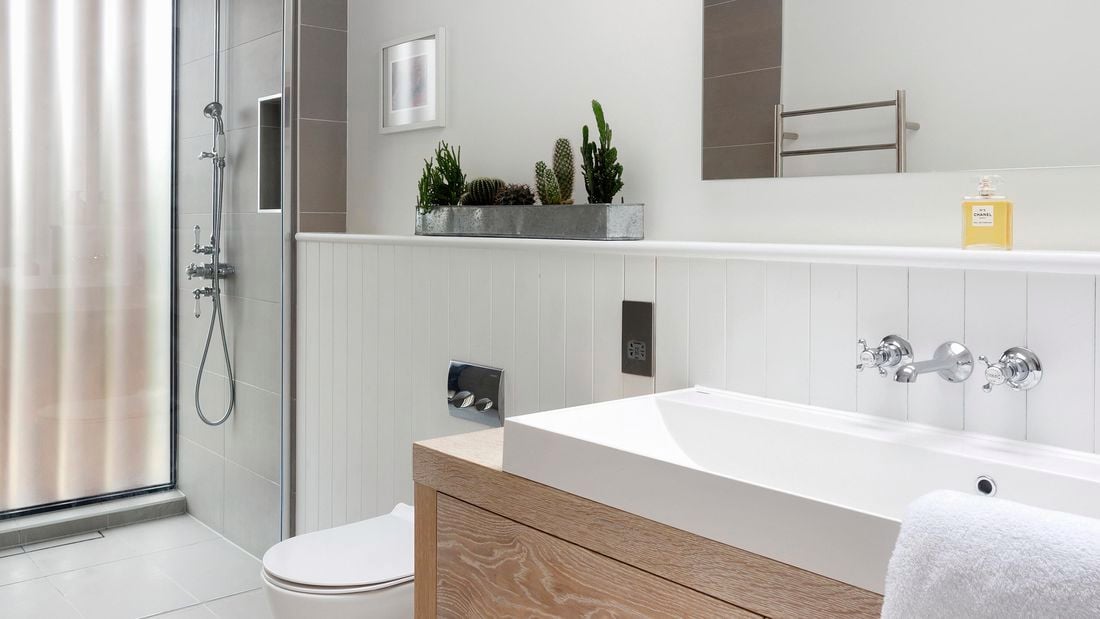 Modern bathroom with wood vanity, grey tiling and silver tapware.