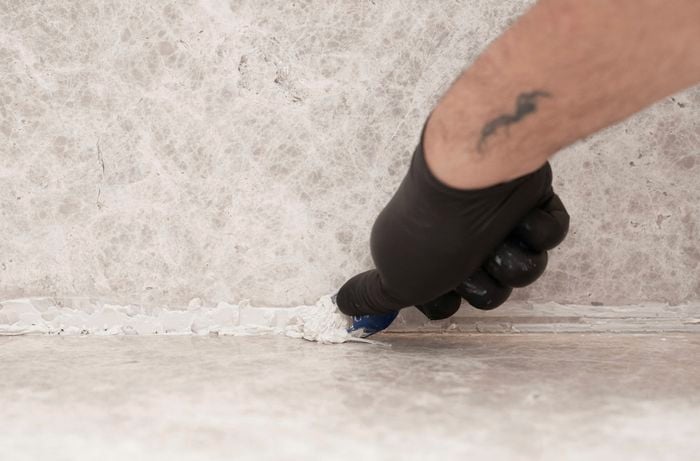Remove excess silicone sealant from a joint with a scraper tool