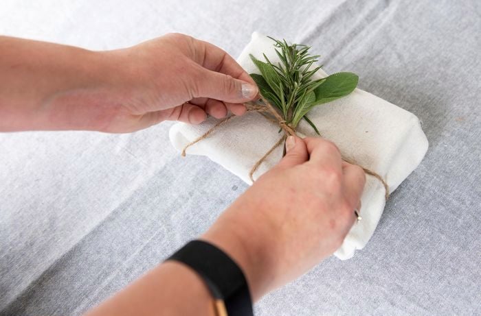 Person tying up present and leaf with string.