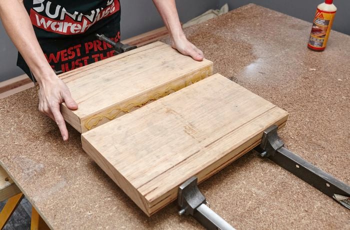 Two pieces of wood being glued together by a Bunnings team member