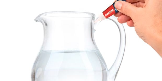 Glass jug handle being repaired with glue.