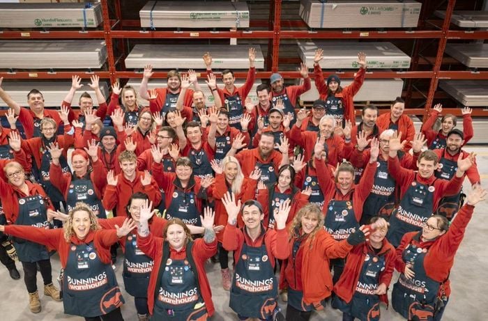 team members in a bunnings store with their hands in the air