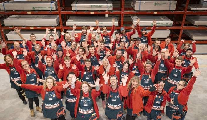 team members in a bunnings store with their hands in the air