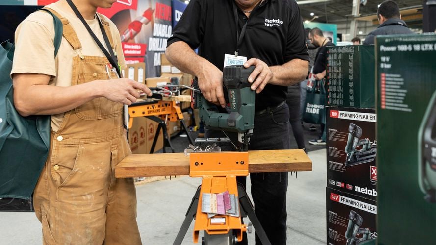 Two trade people trying out a new hammer drill