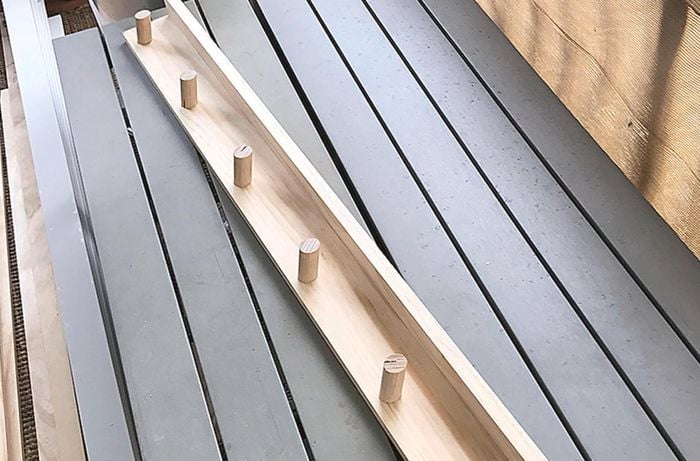 An assembled coat rack laying on an outdoor deck