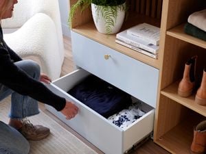 Lady pulling out drawers with clothes inside from Lugna unit.