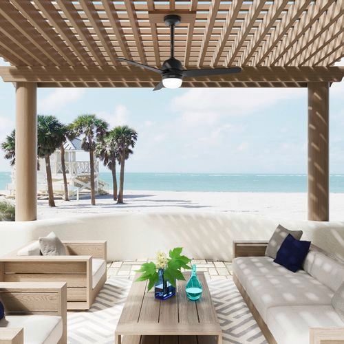 Matte Black Seawave WeatherMax outdoor ceiling fan hanging on a pergola at the beach