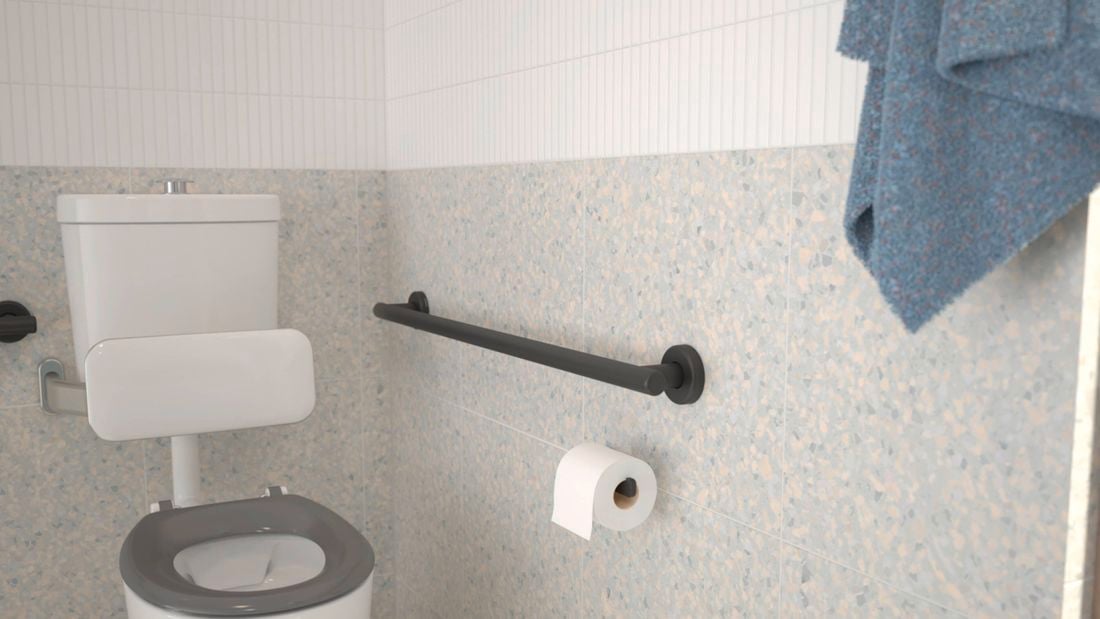 Bathroom with black handrail, white floor and wall tiles and green hand towel hanging on the wall.
