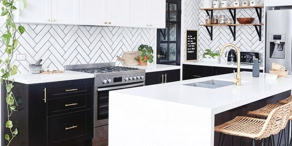 Kitchen with black cabinets and white benchtops.