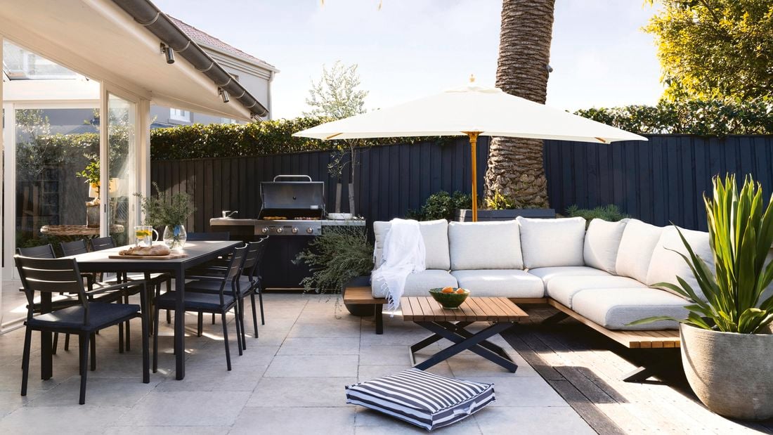 An outdoor entertaining area with a dining table and chairs and a couch